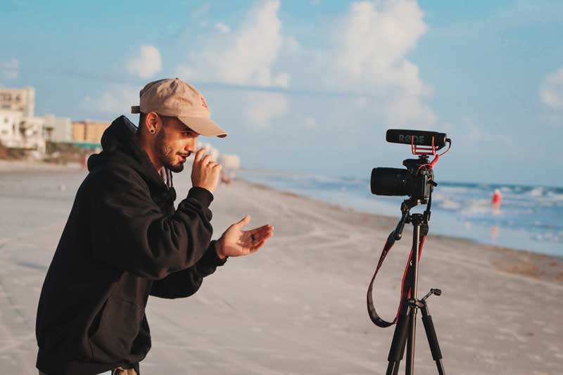 person in black hoodie filming a vlog