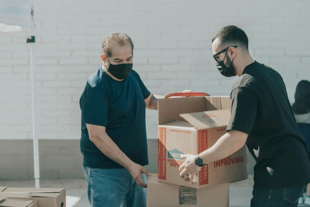 Volunteers happily lifting boxes